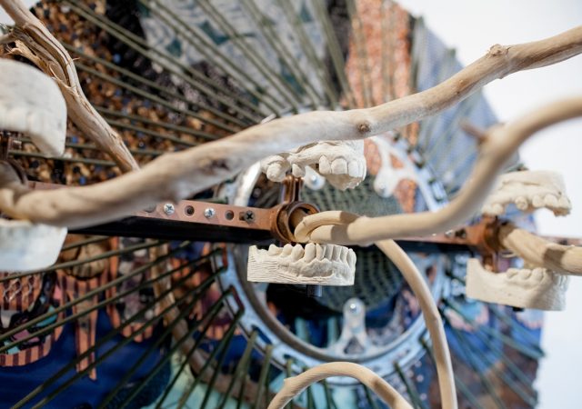 Detail photograph of sculpture, titled Locus, featuring assemblage of natural and mechanical parts, casts of human teeth.